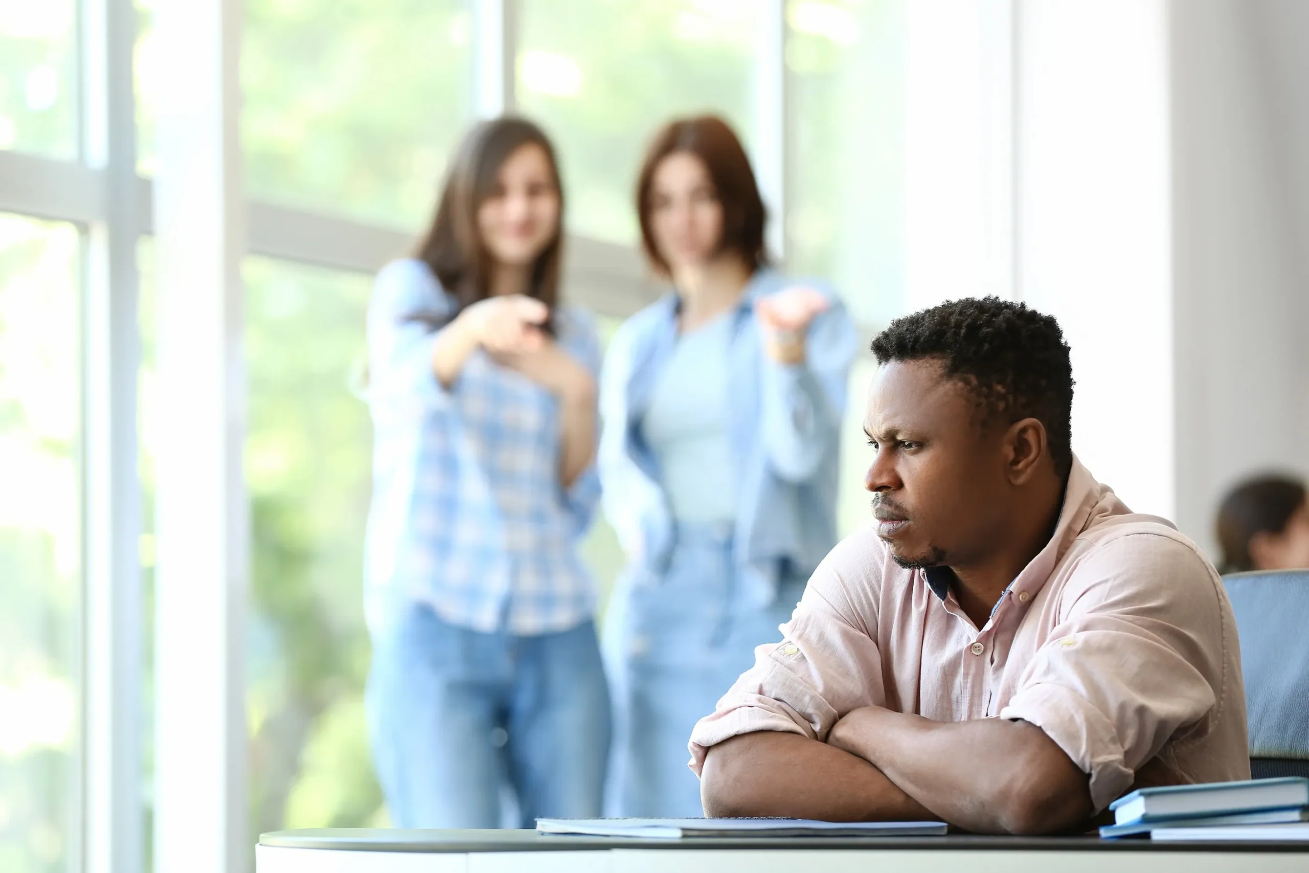 Two female employees harassing a black male colleague.