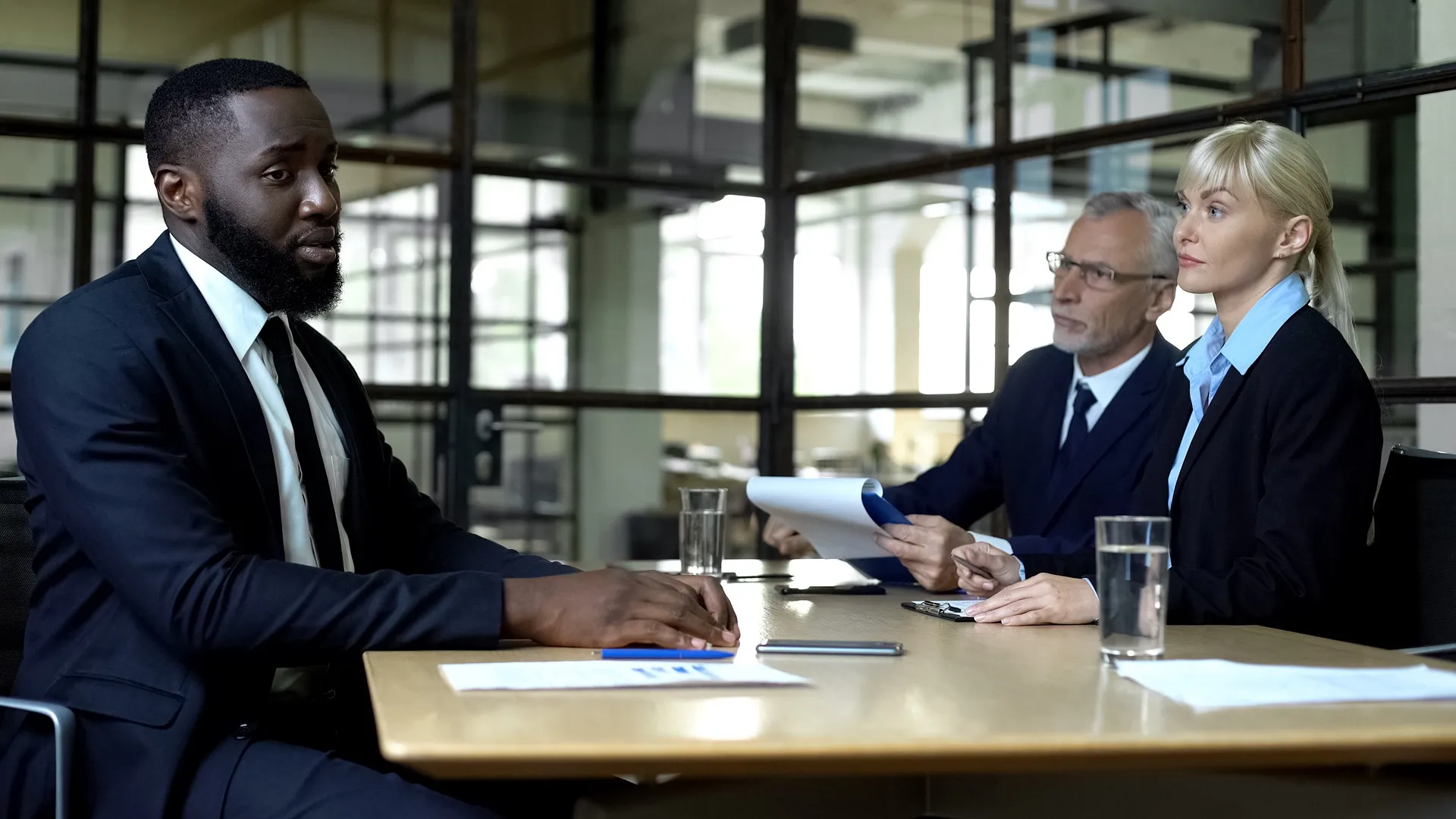 An employee in a work meeting with supervisors.