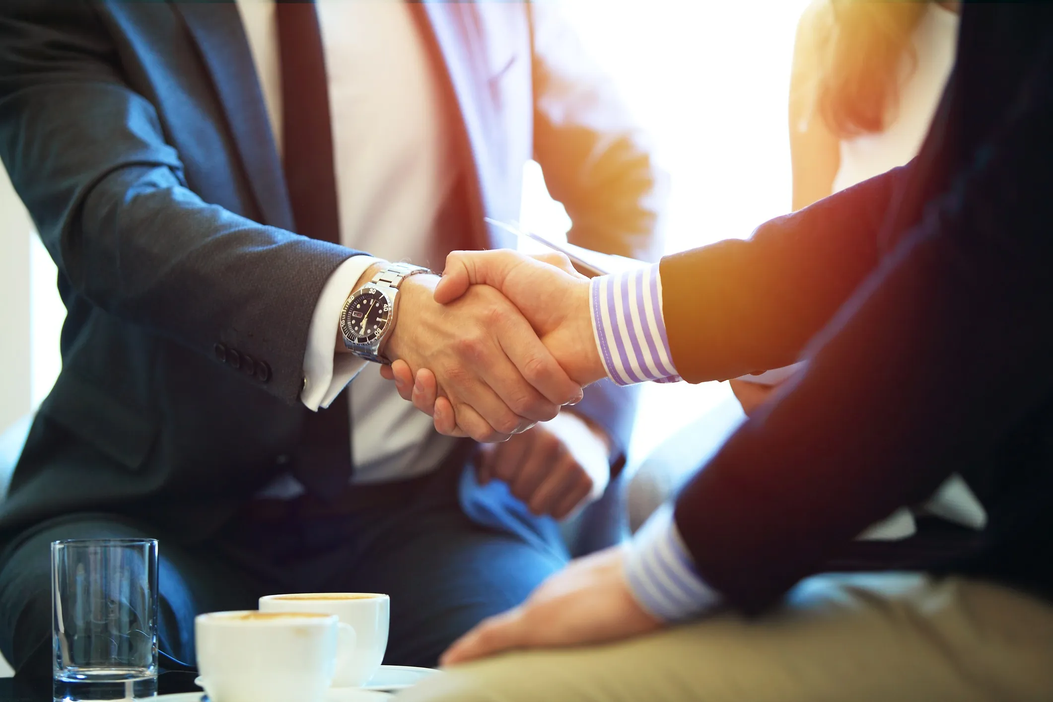 A supervisor and future employee shaking hands after a contract discussion.